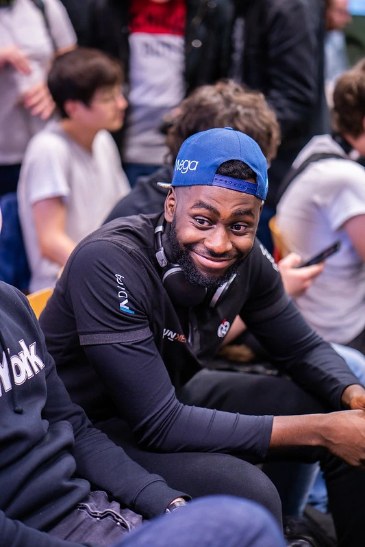 un joueur avec une casquette bleu qui sourit