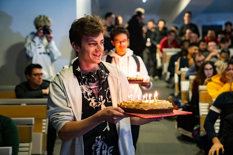 un homme portant un gateau d'anniversaire a son ami pendant un tournoi
