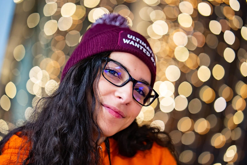 une jeune fille brune avec des lunette qui souris au photographe