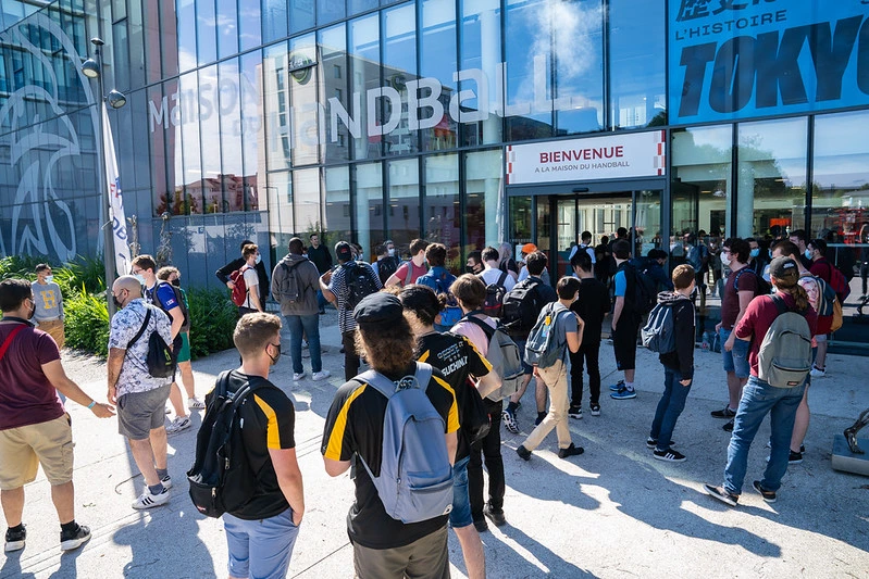 l'entrée de la maison du handball avec plains de joueurs devant qui attendent l'ouverture