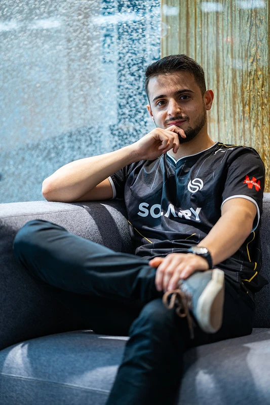 Une jeune beau garçon qui est assis avec un maillot de solary les jambes croisé