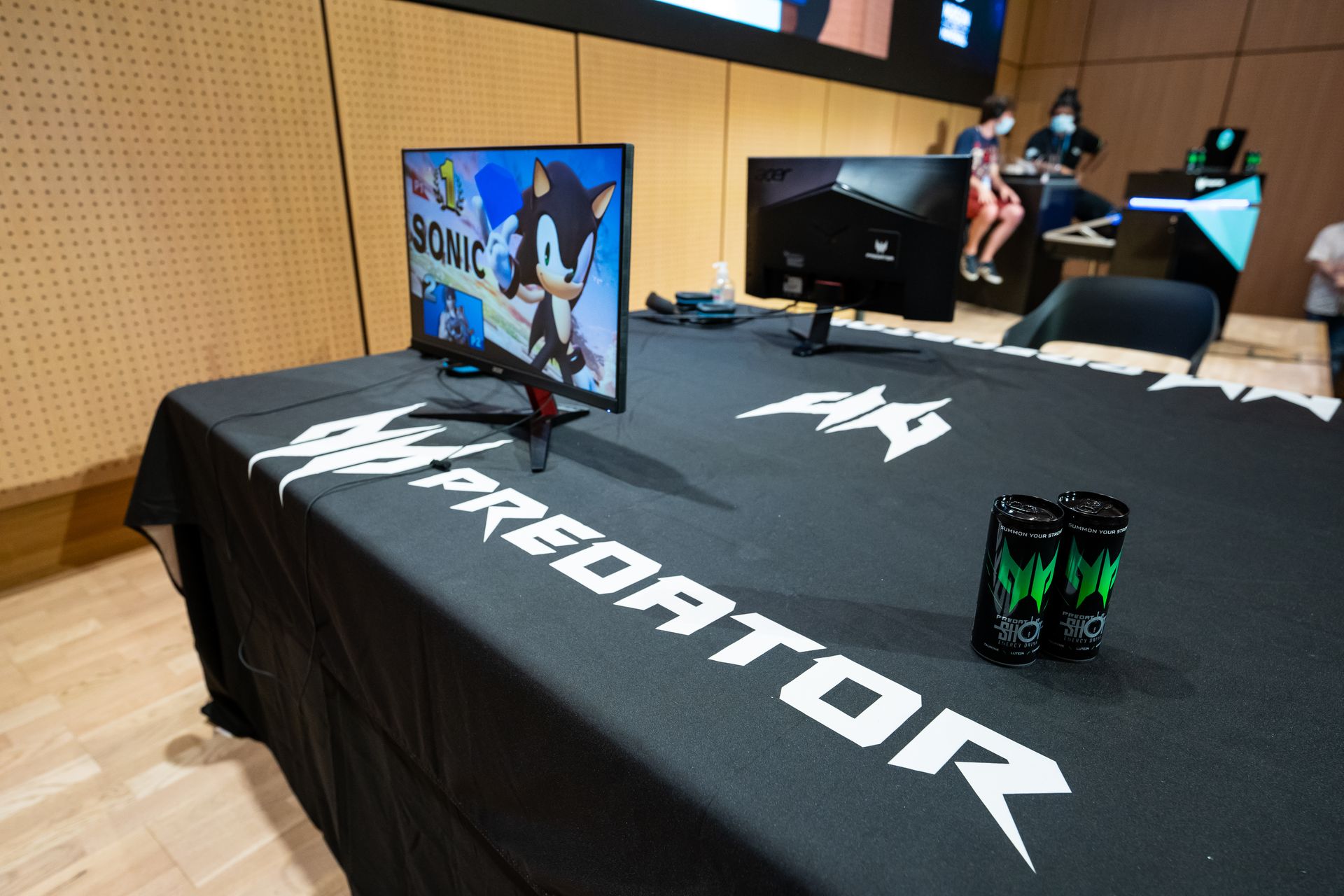 un table sur scène avec 2 moniteur avec un sonic dessus et 2 canettes predator