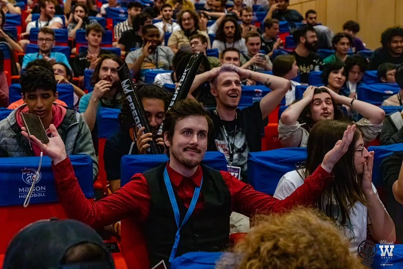 dex qui levent les bras avec un public derrière lui