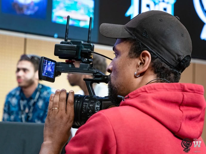 Un cameraman qui filme des joueurs sur scène