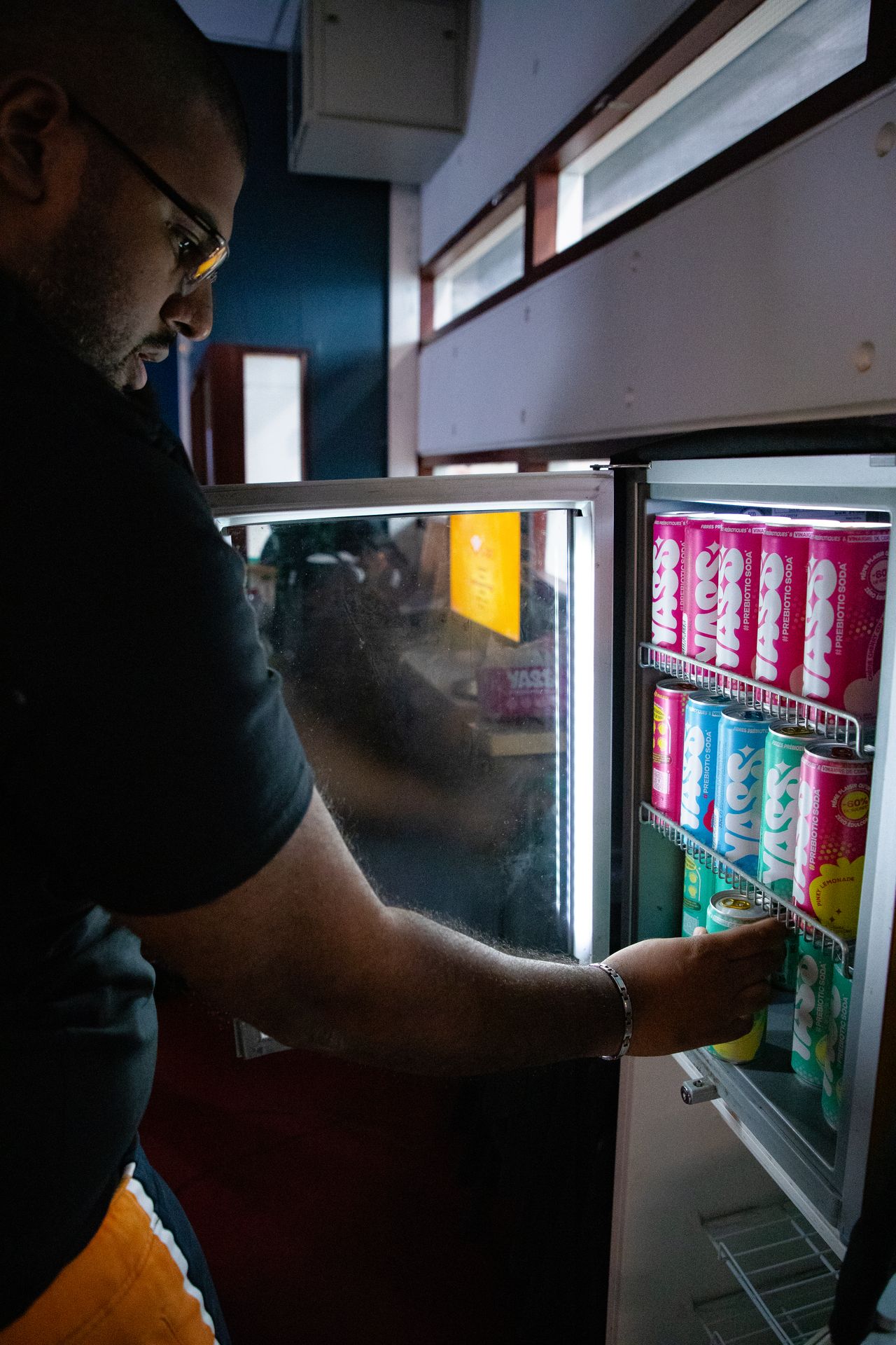 un homme qui se serre de boisson YASS dans le frigo
